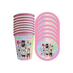 a pink cup with stickers on it next to a stack of plates and cups