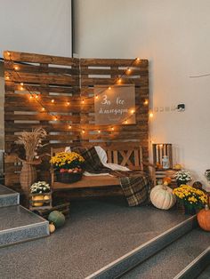 a bed made out of pallets with pumpkins and flowers