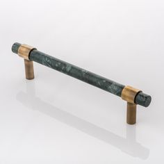 a green marble and brass handle on a white background