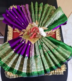 an elaborately decorated fan sitting on top of a table