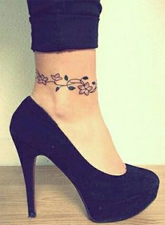 a woman's ankle tattoo with flowers on it