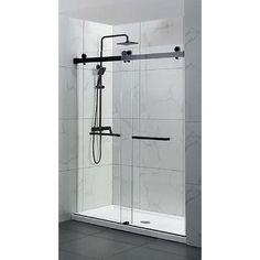 a walk in shower sitting next to a white tiled wall and black tile flooring