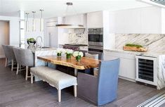 a kitchen with marble counter tops and white cabinets, along with blue upholstered chairs