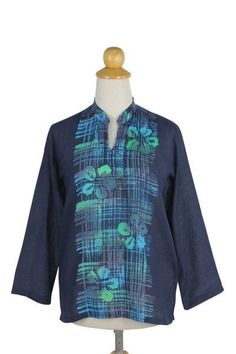 Batik motifs blossom as hibiscus flowers in this stylish deep blue tunic by Chomsuda Samana. Crafted of cool lightweight woven cotton the top features a mandarin collar and slips over the head. The patterns are repeated on the back. Blue Hawaiian Long Sleeve Tops, Blue Long Sleeve Hawaiian Top, Spring Batik Print Relaxed Tops, Spring Batik Print Relaxed Fit Tops, Casual Blue Batik Print Top, Indigo Floral Print Cotton Top, Indigo Cotton Floral Print Tops, Summer Floral Print Indigo Top, Indigo Floral Print Tops For Summer