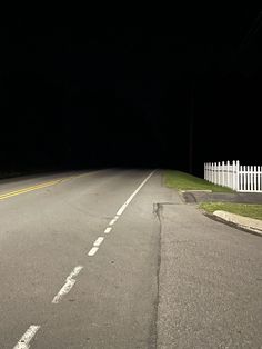 an empty street at night with the light on and no one in it is driving