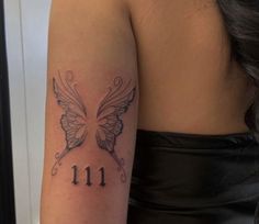 a woman's arm with a butterfly tattoo on the upper half of her arm