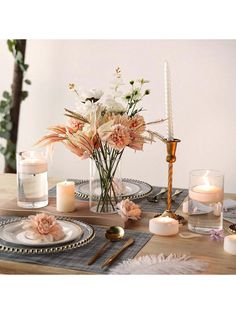 the table is set with candles, flowers and other things to put on it's placemats