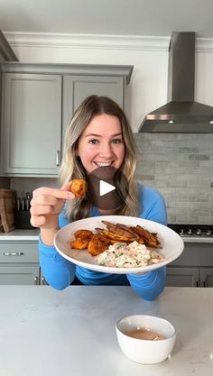 a woman holding a plate with food on it