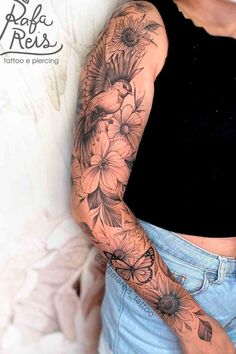 a woman with a tattoo on her arm and some flowers in the middle of her arm