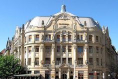 a large building with many windows and people walking around