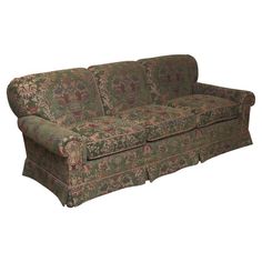 a green floral couch sitting on top of a white floor