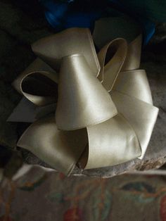 a pile of white bows sitting on top of a bed next to a blue pillow