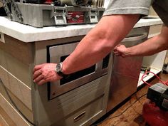 a man is opening an oven door in the kitchen