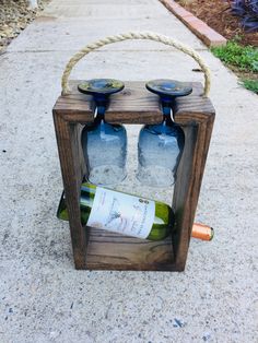 two wine bottles in a wooden box on the sidewalk