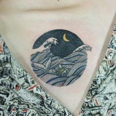 a woman with a tattoo on her chest has a wave and the moon above it