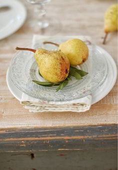 two pears are sitting on a glass plate