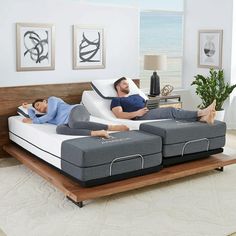 two people laying on top of mattresses in a living room next to each other