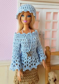 a doll is wearing a crocheted outfit and hat