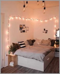 a bed room with a neatly made bed and string lights