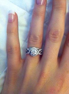 a close up of a person's hand with a diamond ring on their finger