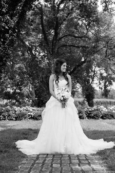 a woman in a wedding dress is posing for the camera