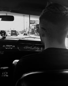 a man sitting in the driver's seat of a car with his head up