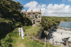 A bride and groom walking towards a big house next to the sea in Cornwall. Cornwall Wedding Venues, Back Garden Wedding, Wedding By The Sea, Cornish Wedding, Cornwall Wedding, Uk Beaches, Smallest Wedding Venue, Sea Wedding, Wedding Venues Uk