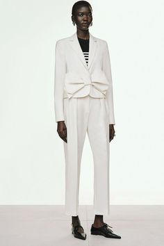 a model in a white suit and black shoes