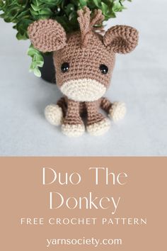 a crocheted stuffed animal sitting next to a potted plant with the words duo the donkey on it