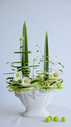 a white vase filled with flowers and plants