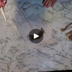 a person is making something with scissors and wire on the counter top that looks like marble