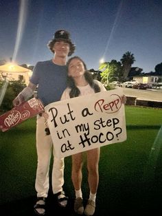 a man and woman standing in the grass holding a sign that says put a pep in my step at hoco?