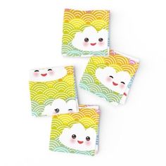 four square coasters with clouds and smiling faces on them, all in different colors