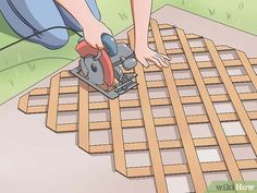 a person using a circular saw to cut wood planks on the ground with a power tool