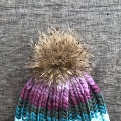 "D E T A I L S + A warm & soft hand knitted, oversized beanie with faux fur pompom + The beanie color is a geode - purple, turquoise, greens + Made with a soft blend of wool &acrylic. + Adult size + Hand wash, dry flat + READY TO SHIP! M E A S U R E M E N T S Adult - 23\" / 58.5cm >> Check shop announcement for current turn around time. >> Please let me know before purchasing if you need an item in a certain time frame. >> SHIPPING: First Class, Priority Mail, & Pri Oversized Beanie, Lapel Brooch, Felt Heart, Pink Baby Girl, Purple Turquoise, Paper Gift Box, Skull Cap Beanie, Soft Hand, Heart Jewelry