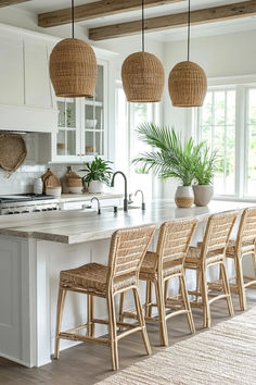 a kitchen with white cabinets and wicker chairs in front of an island countertop