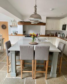 a kitchen table with four chairs around it and a center island in the middle of the room