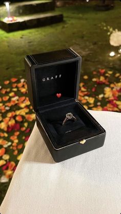 an open box with a ring inside sitting on a table