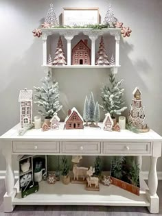 a white table topped with christmas decorations and figurines on top of each shelf