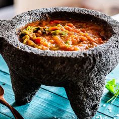 a bowl filled with soup sitting on top of a wooden table