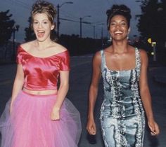 two young women walking down the street at night, dressed in evening gowns and tulle skirts