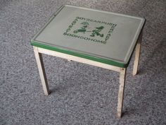 a small green and white table sitting on the floor