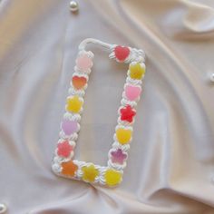 the letter i is made out of multicolored beads