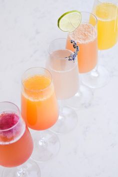 three glasses filled with different types of drinks next to each other on a white surface