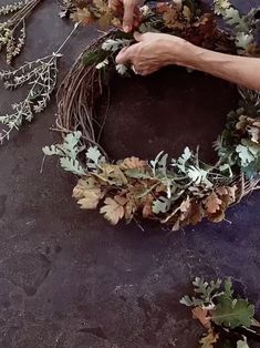 someone is making a wreath out of branches and leaves