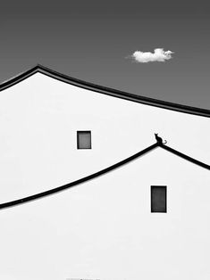 a black and white photo of a building with three square windows