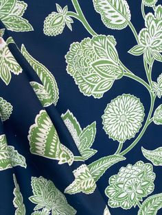 a blue and green floral print fabric with white flowers on the front, dark blue background