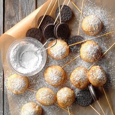 an assortment of cookies and oreos on skewers next to a bowl of powdered sugar