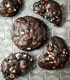 several chocolate cookies with white and orange sprinkles