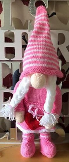 a pink and white stuffed animal wearing a knitted hat